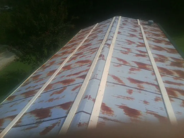 Rusted metal roof panels with new wood purlins before replacement — Storm Damage Roof Repair in Du Quoin by Roofing Brothers