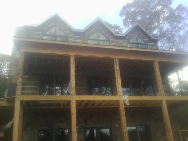 Dormers and porch framing on a large log home under construction — Roof Coating work by our crew in Du Quoin