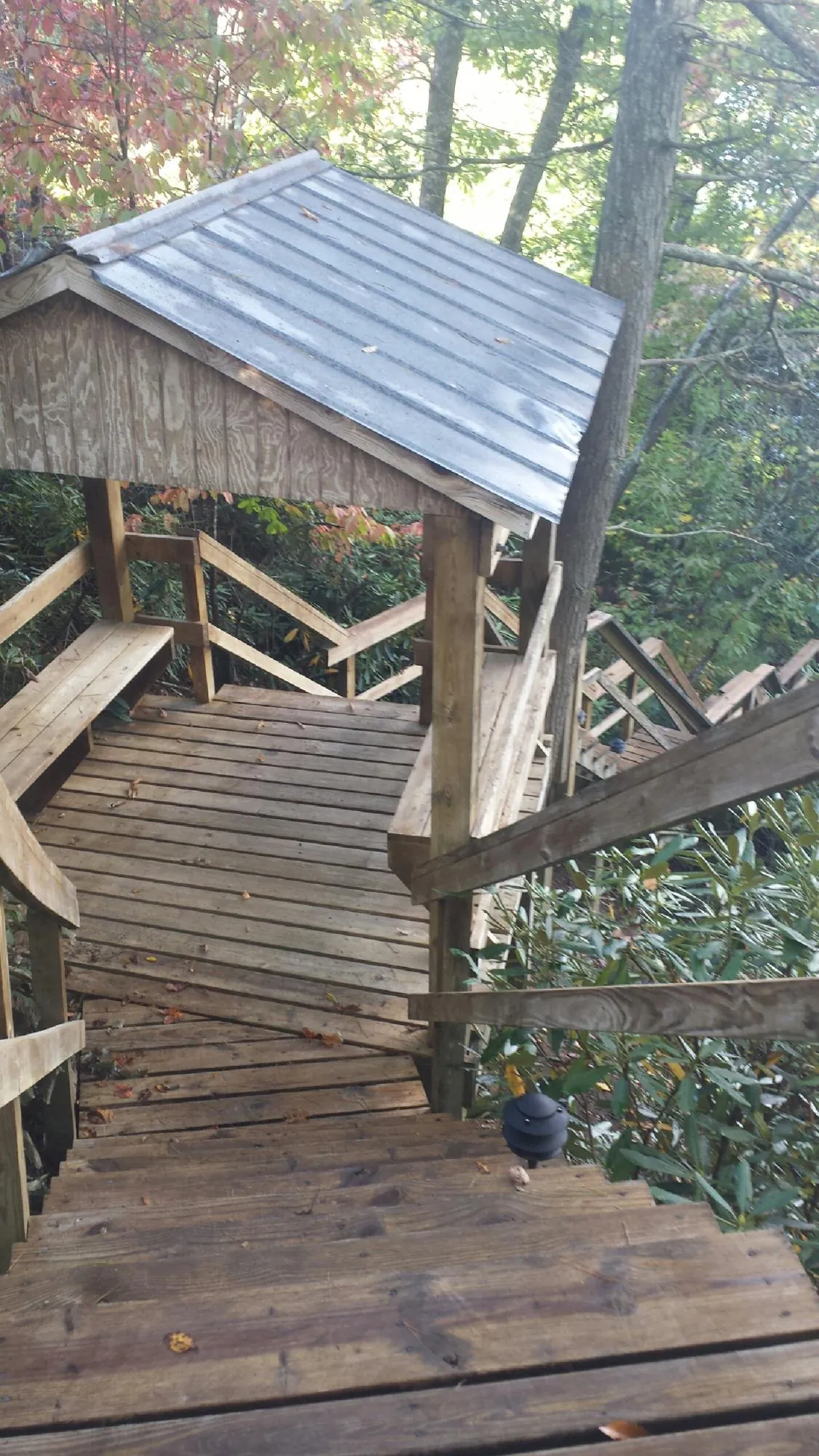 Metal roofed shelter over wooden steps on a wooded walkway — Skylight Repair & Installation work by our crew in Du Quoin