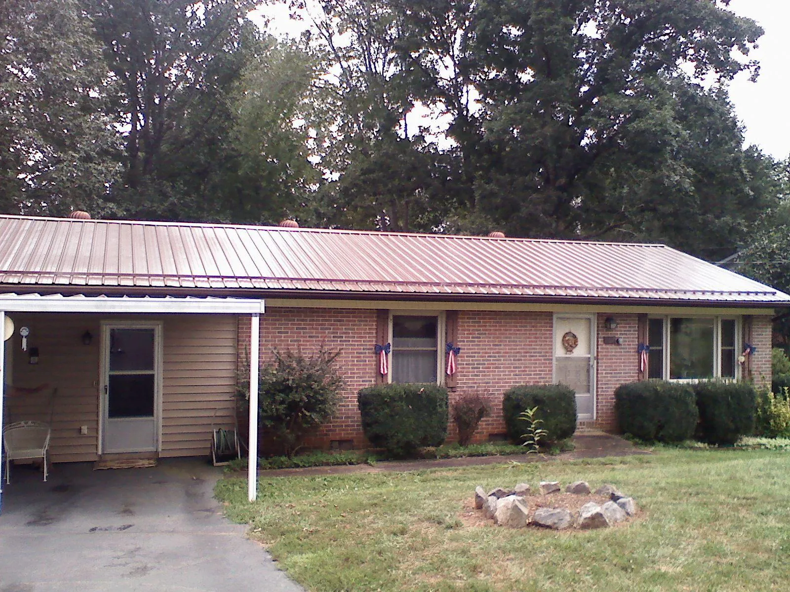 Bronze metal roof and carport on a brick ranch home — Roof Repair work by our crew in Du Quoin